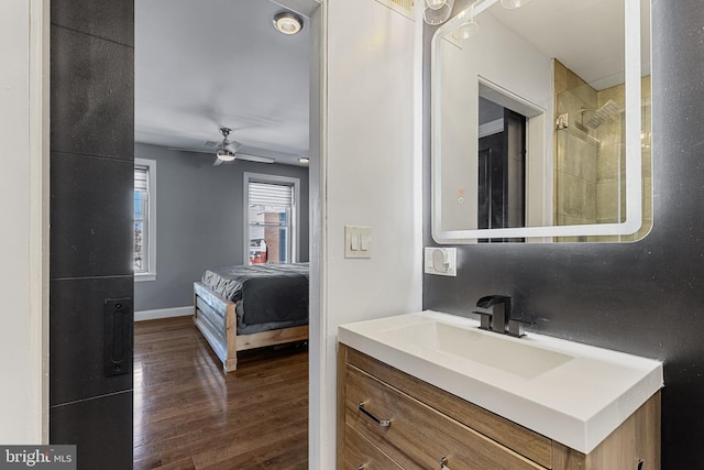 bathroom featuring vanity, wood finished floors, baseboards, and ceiling fan