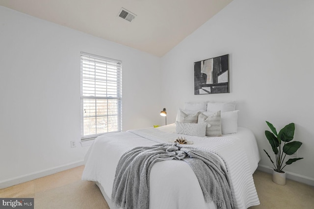 bedroom featuring visible vents, lofted ceiling, light colored carpet, and baseboards