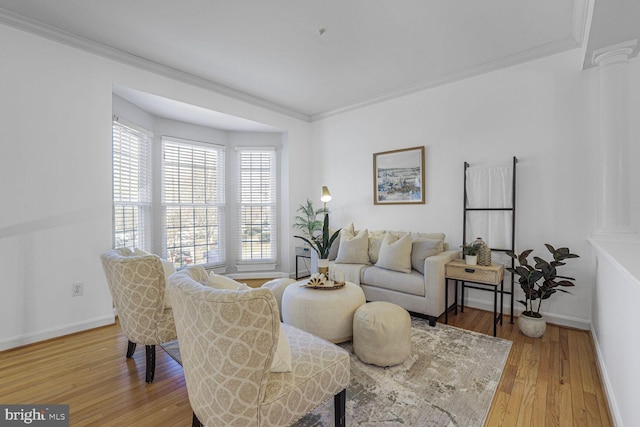 living area with light wood-style flooring, crown molding, and ornate columns