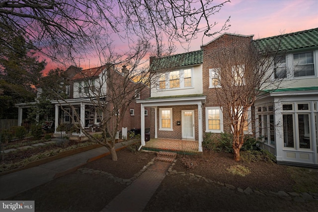 view of front of home featuring a porch and brick siding