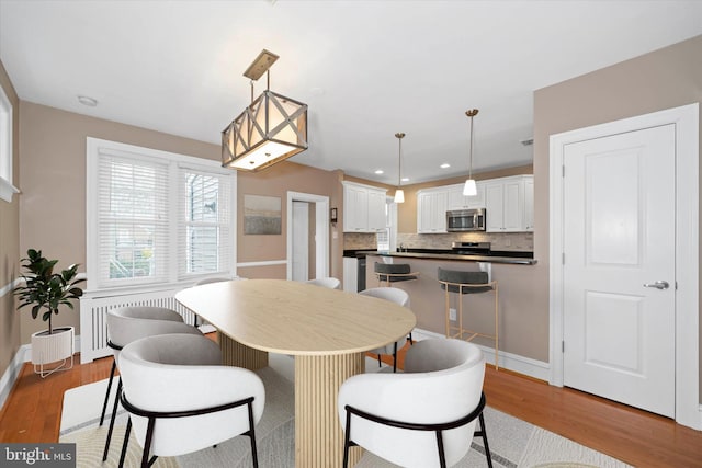 dining space with recessed lighting, baseboards, and wood finished floors