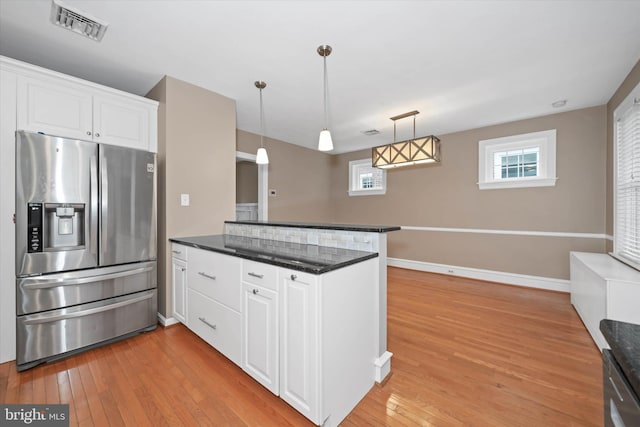 kitchen featuring visible vents, a peninsula, appliances with stainless steel finishes, white cabinetry, and light wood-type flooring