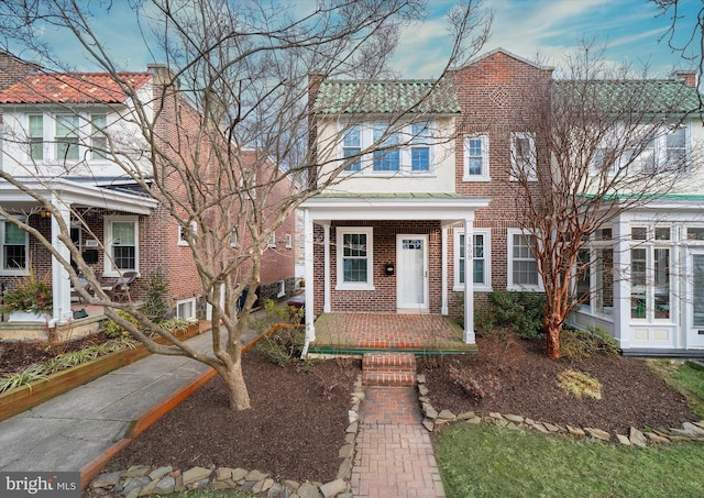 view of front of home with brick siding and covered porch