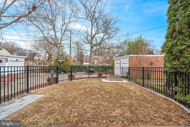 view of yard with an outbuilding, fence, and a residential view