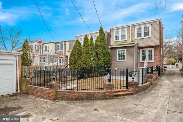 view of front facade featuring driveway, a garage, and a fenced front yard