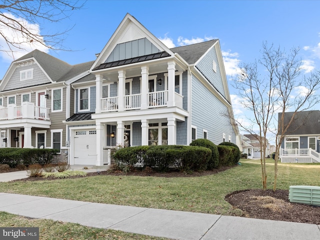 view of front of home featuring a balcony, a standing seam roof, a front lawn, board and batten siding, and metal roof