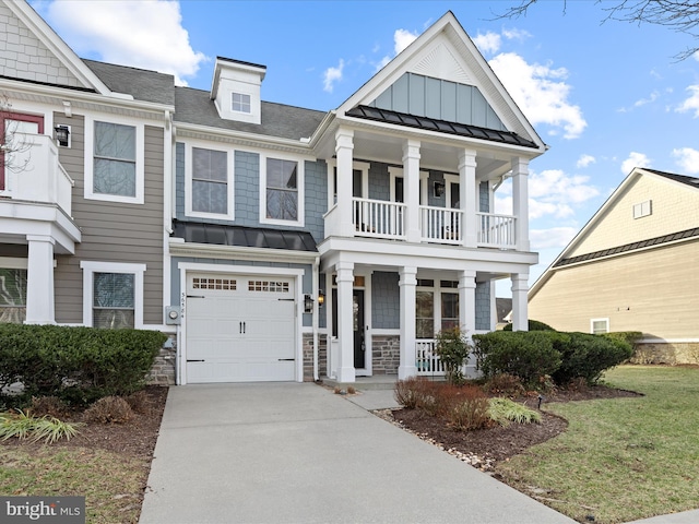 view of front of house with a porch, a garage, a balcony, driveway, and a standing seam roof