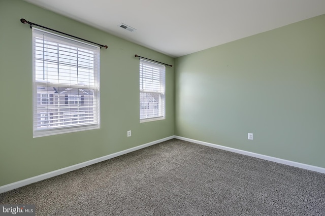 carpeted empty room with baseboards and visible vents