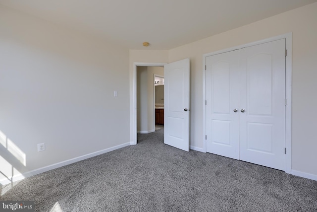 unfurnished bedroom featuring carpet, baseboards, and a closet