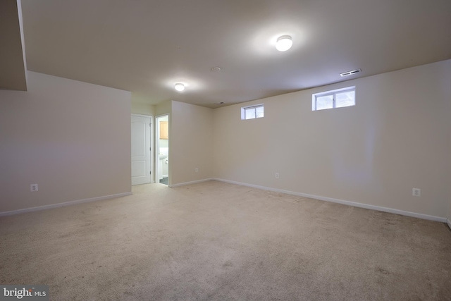 empty room with visible vents, light colored carpet, and baseboards