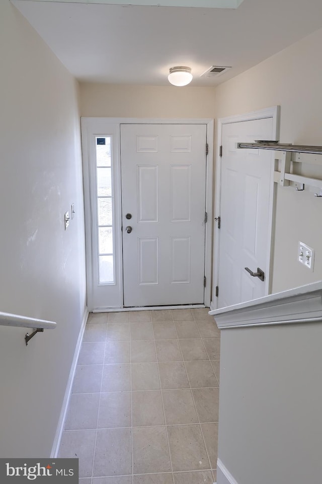 entryway with light tile patterned floors, visible vents, and baseboards