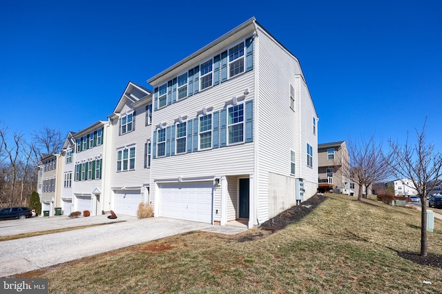 exterior space with an attached garage, a lawn, a residential view, and driveway