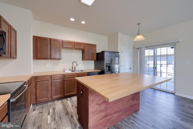 kitchen featuring black appliances, recessed lighting, light wood-style floors, and a sink