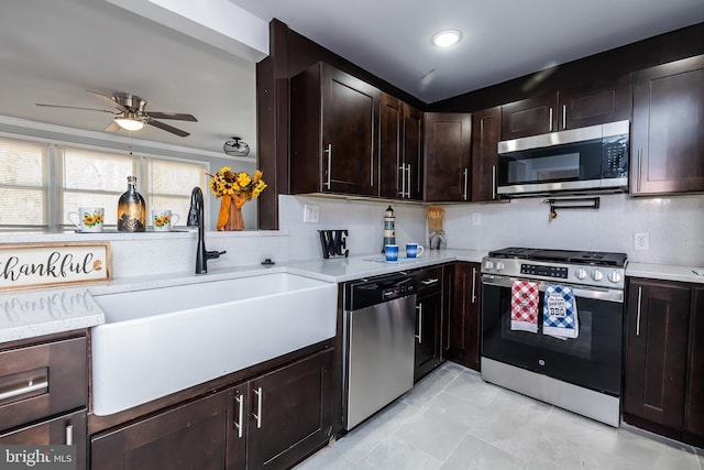 kitchen with a ceiling fan, a sink, stainless steel appliances, light countertops, and dark brown cabinets