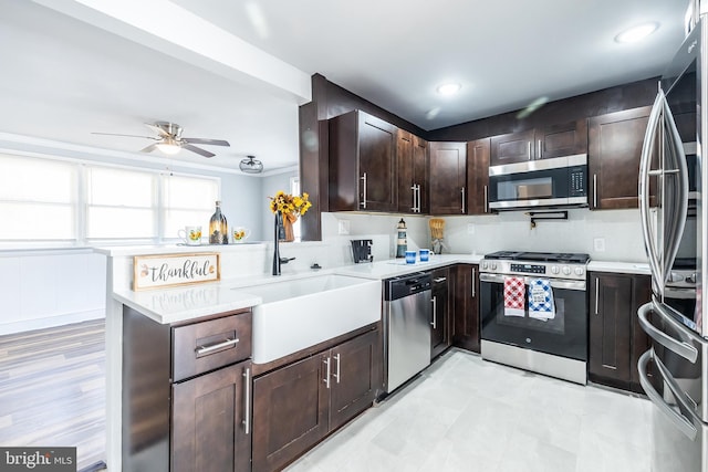 kitchen featuring a sink, stainless steel appliances, ceiling fan, and light countertops