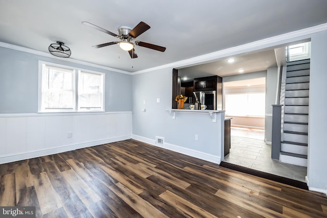 interior space featuring a ceiling fan, plenty of natural light, wood finished floors, and visible vents