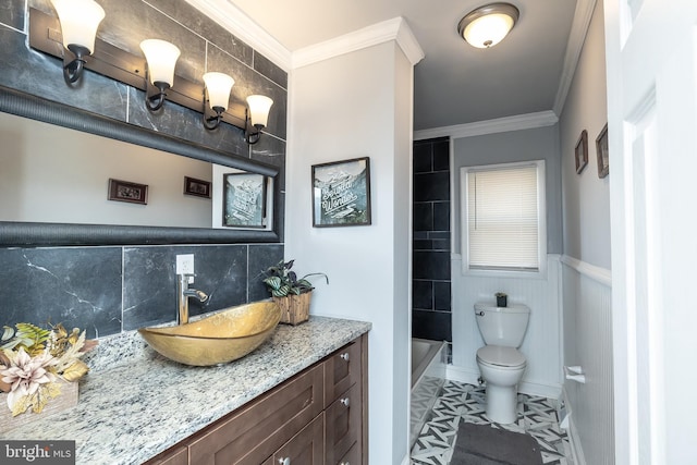 bathroom featuring backsplash, baseboards, toilet, ornamental molding, and vanity