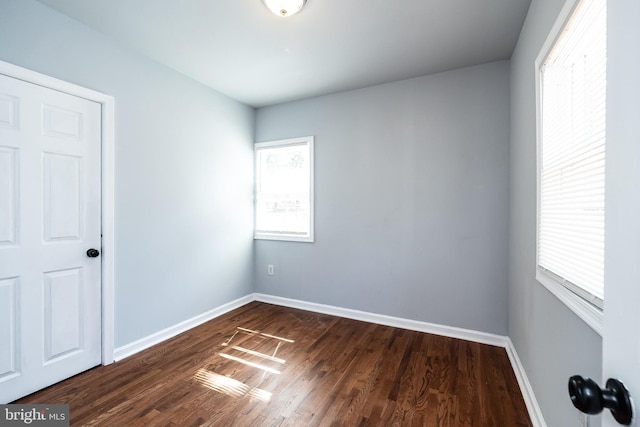 unfurnished room with dark wood finished floors and baseboards