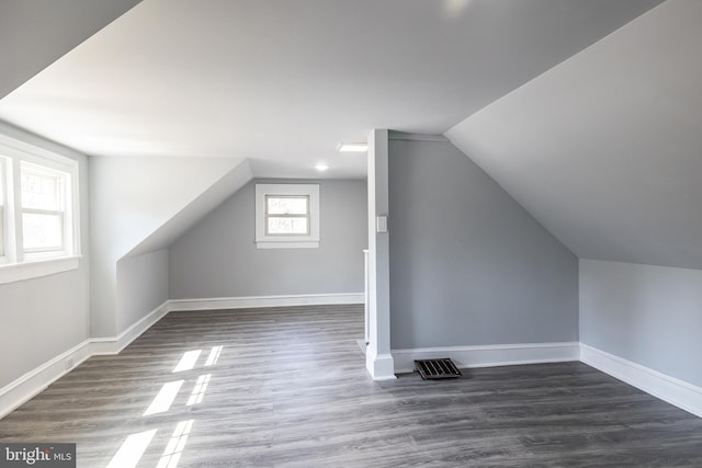 bonus room featuring baseboards, wood finished floors, and vaulted ceiling