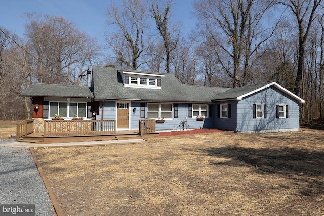 view of front of house with roof with shingles and a wooden deck