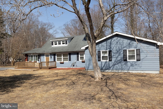 view of front facade with a wooden deck and roof with shingles