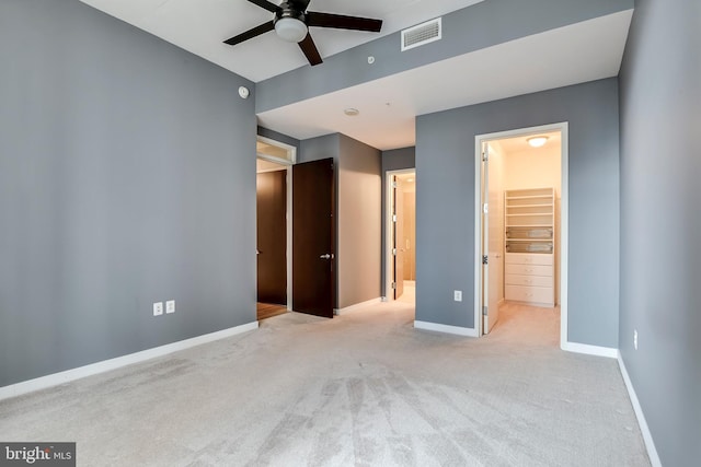 unfurnished bedroom featuring a spacious closet, visible vents, carpet, and baseboards