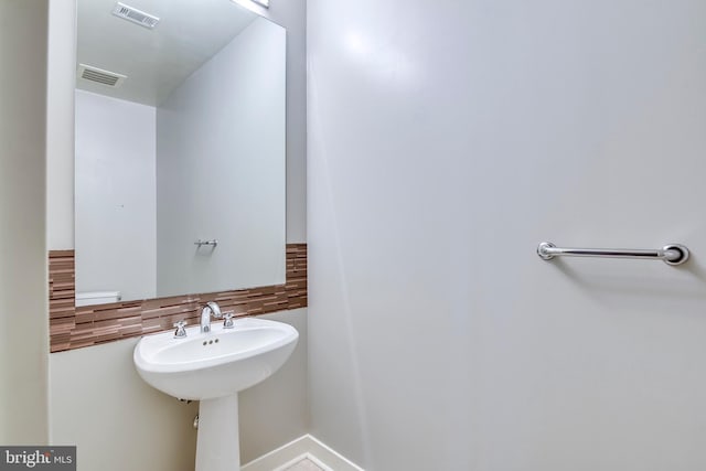 bathroom with visible vents, a sink, and decorative backsplash