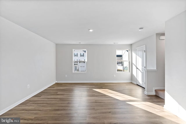 unfurnished living room featuring baseboards and wood finished floors