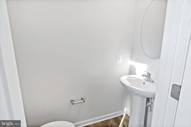 bathroom featuring a sink, baseboards, and wood finished floors