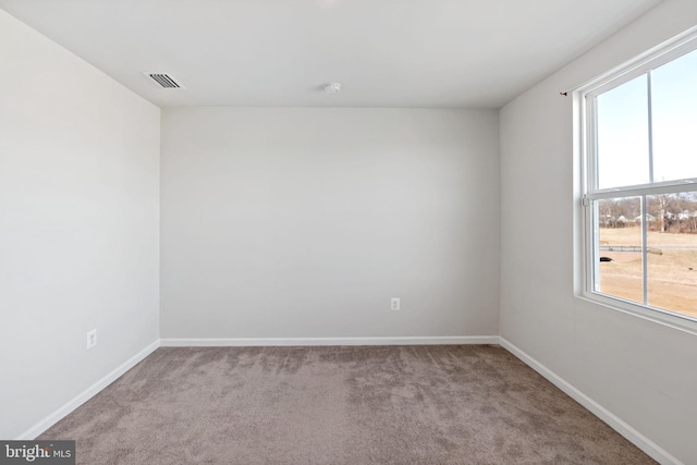 carpeted empty room with visible vents and baseboards