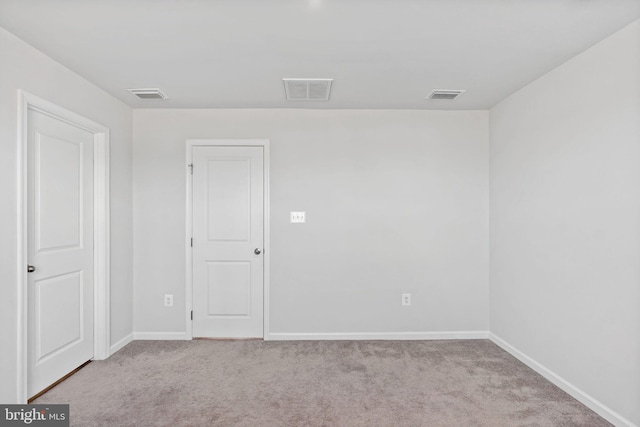 carpeted empty room featuring visible vents and baseboards