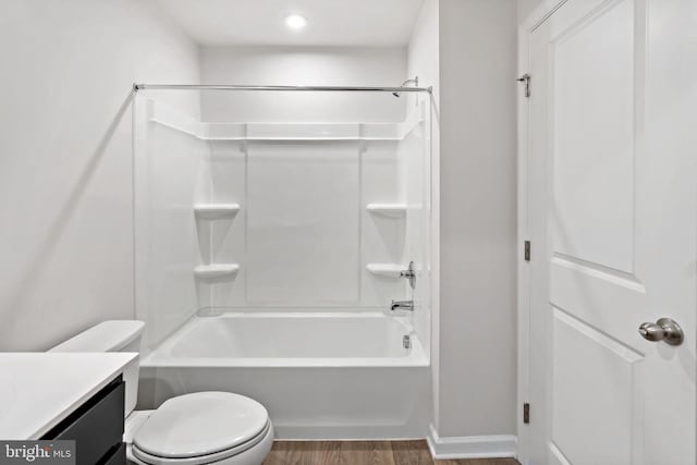 full bathroom with toilet, wood finished floors, vanity, baseboards, and shower / bathtub combination