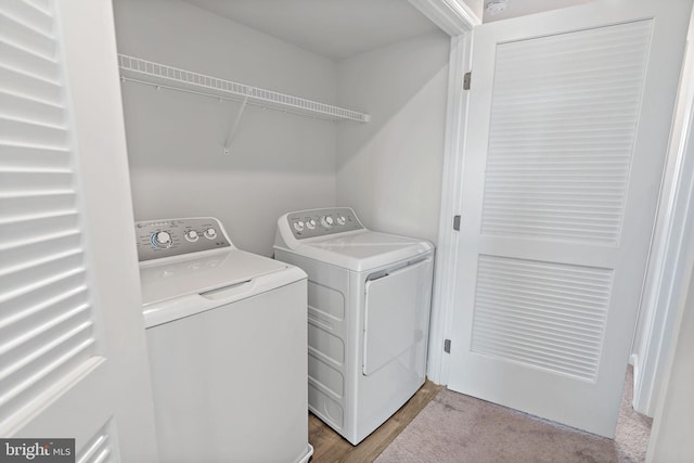 laundry room featuring laundry area, wood finished floors, and washing machine and clothes dryer