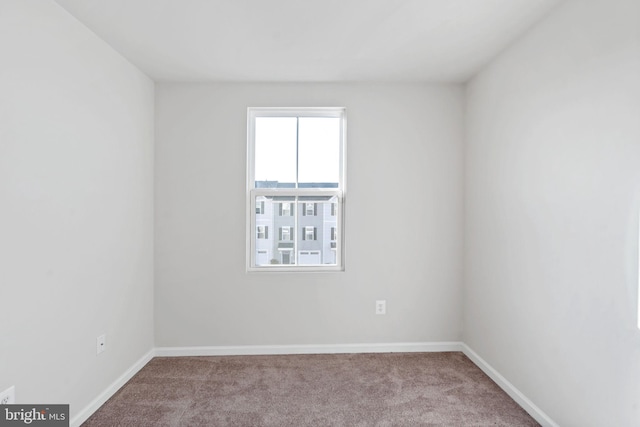 empty room featuring baseboards and carpet flooring