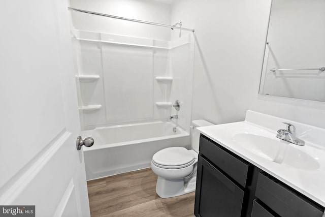 bathroom featuring toilet, vanity, shower / bathtub combination, and wood finished floors