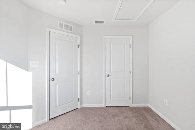 unfurnished bedroom with carpet flooring, baseboards, and visible vents