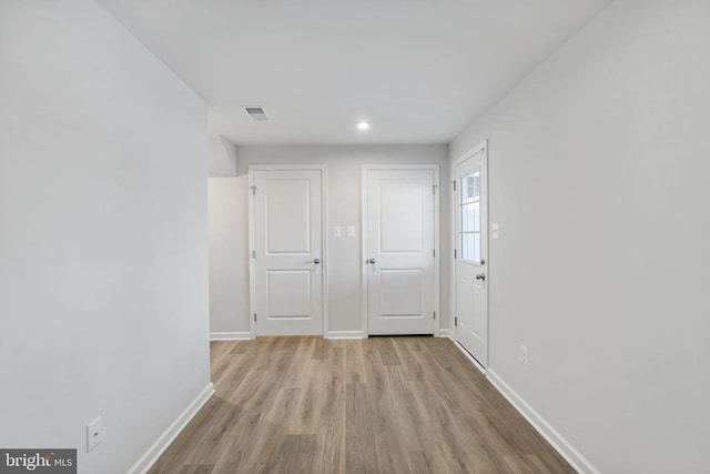 hall featuring wood finished floors, recessed lighting, visible vents, and baseboards