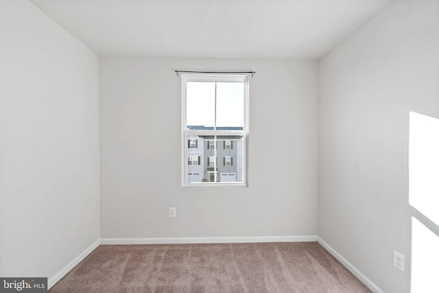 carpeted empty room with baseboards