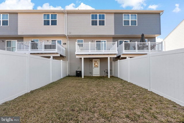 back of house with a yard, central AC, and a fenced backyard