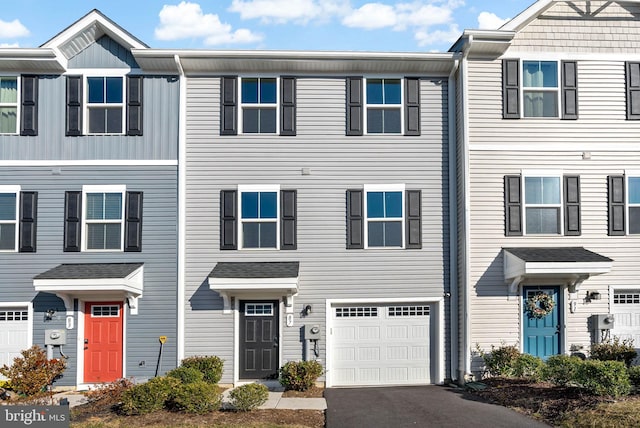 multi unit property featuring a garage and driveway