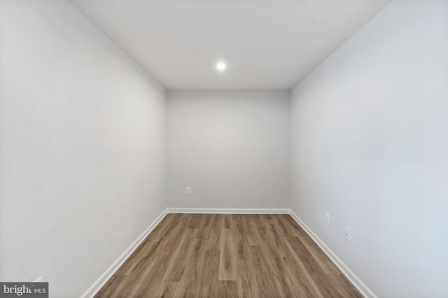 spare room featuring baseboards and wood finished floors