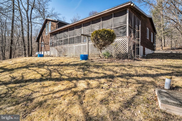 view of side of home featuring a yard and a sunroom