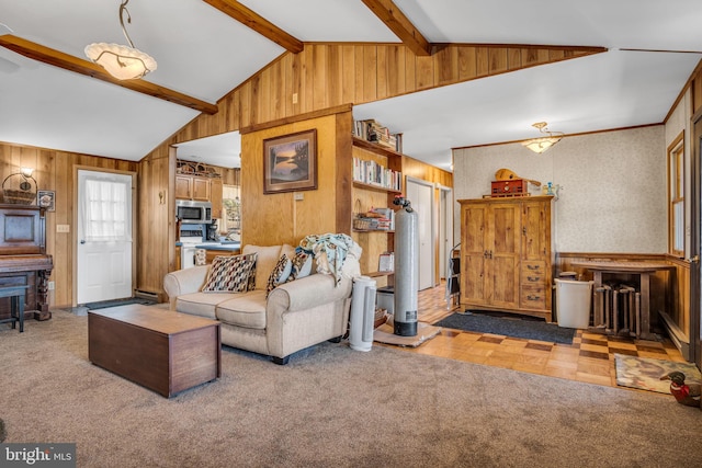 carpeted living room with lofted ceiling with beams and wooden walls