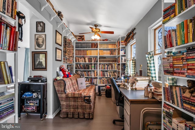 office space with a ceiling fan and bookshelves