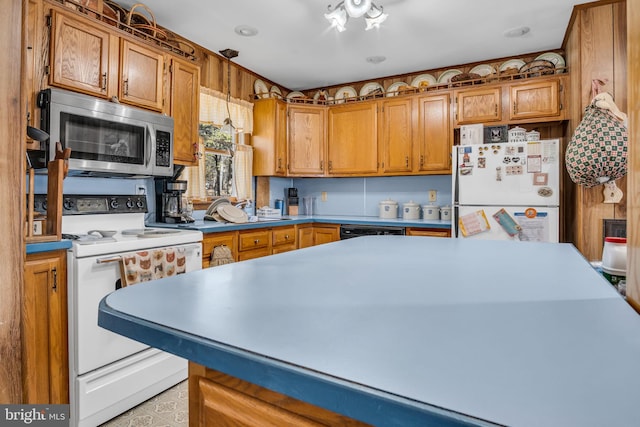 kitchen featuring white appliances, brown cabinetry, and light countertops