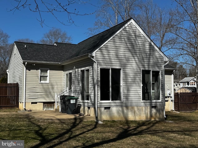 rear view of house featuring a patio, fence, a lawn, and crawl space