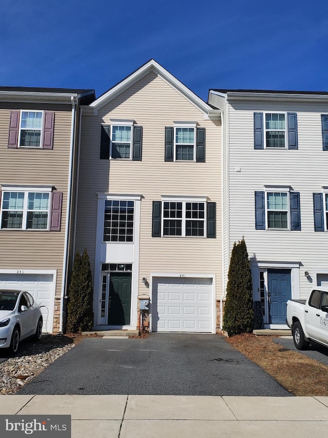 multi unit property featuring a garage and driveway