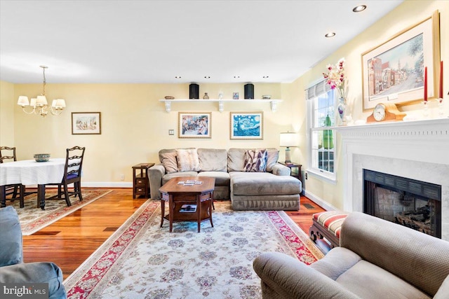 living area with recessed lighting, a fireplace, baseboards, and wood finished floors