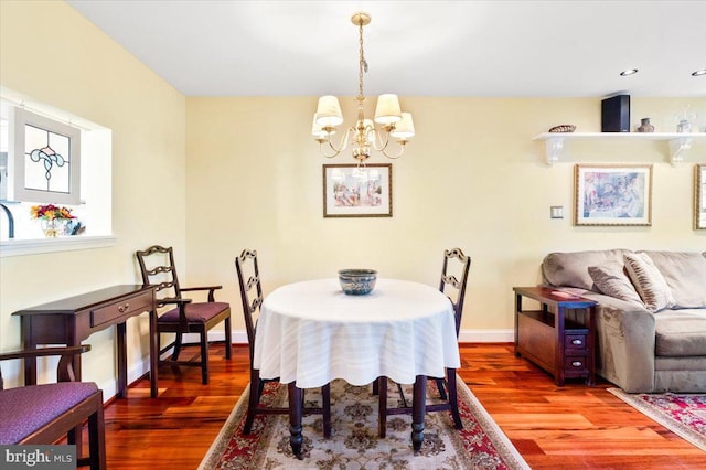 dining room with a notable chandelier, baseboards, and wood finished floors