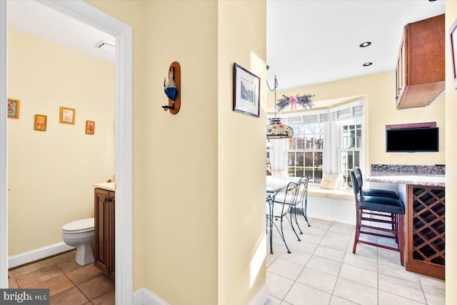 hallway featuring light tile patterned floors, baseboards, and recessed lighting